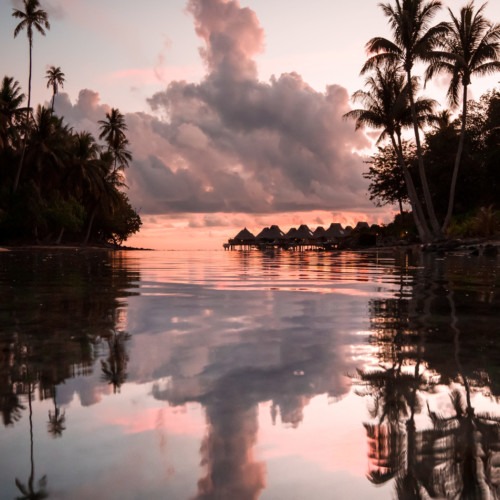 Sunset avec vue sur les maisons flottantes de l'hotel Conrad de Bora Bora en Polynésie française