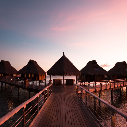 Sunset sur les maisons flottantes de l'hotel Conrad de Bora Bora en Polynésie Française